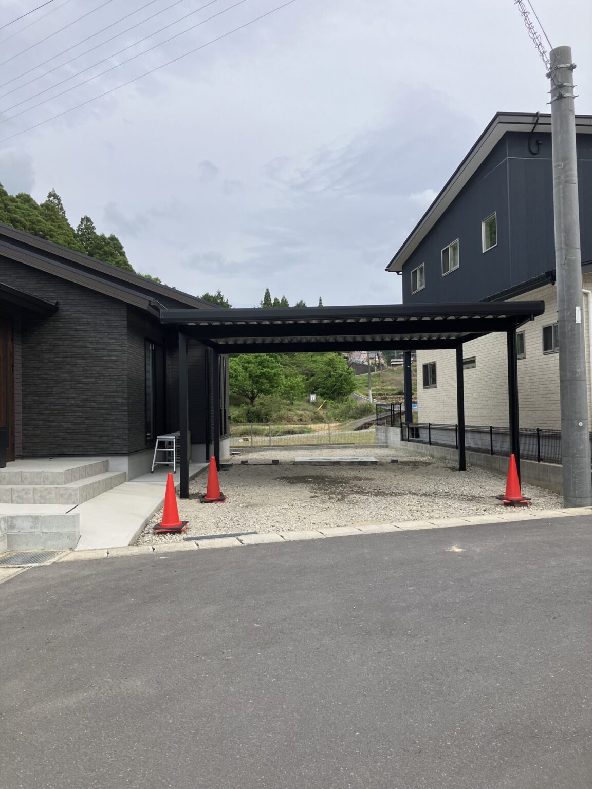 福岡県内 オリジナル折板屋根カーポート 山あいの景色を望む住宅の駐車スペース