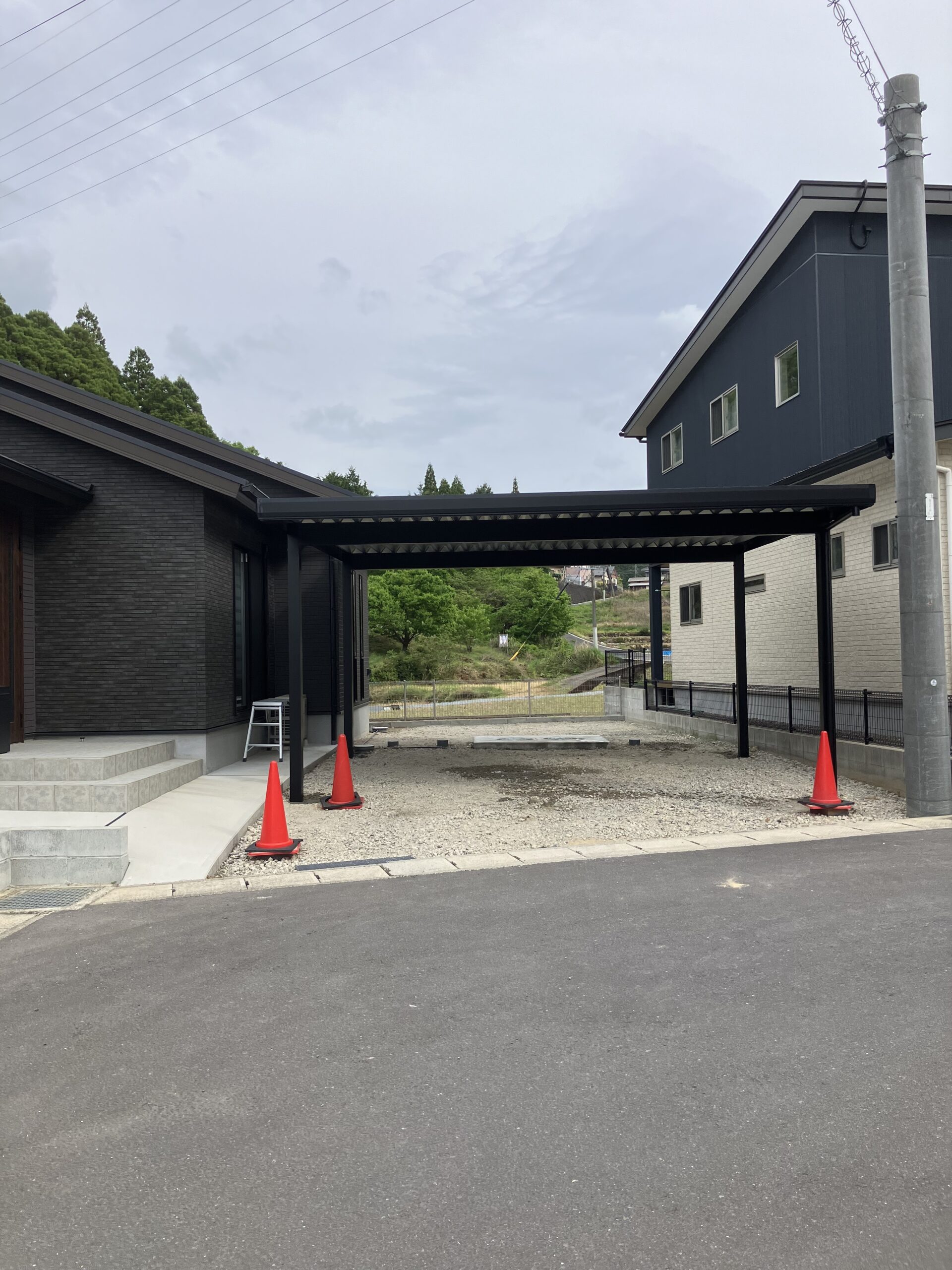 福岡県内 オリジナル折板屋根カーポート 山あいの景色を望む住宅の駐車スペース