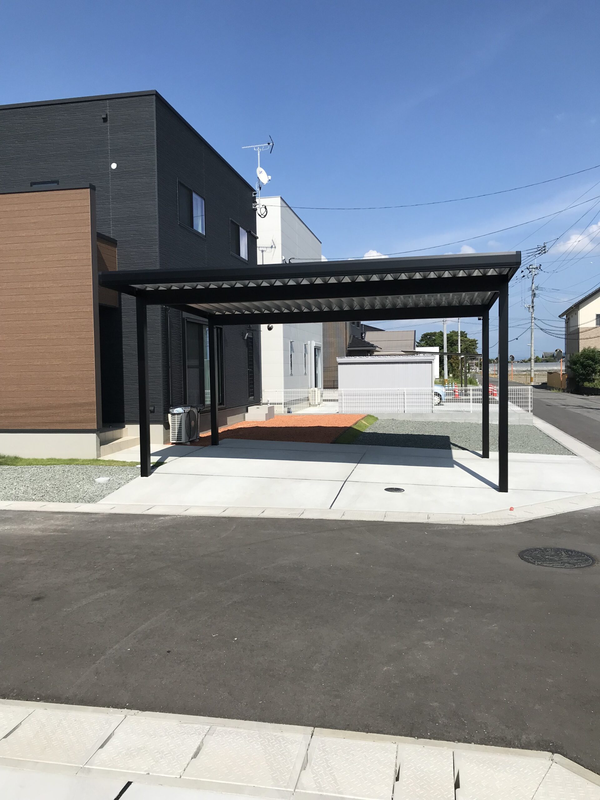 福岡県内 オリジナル折板屋根カーポート ウッド調玄関と調和するブラックフレーム