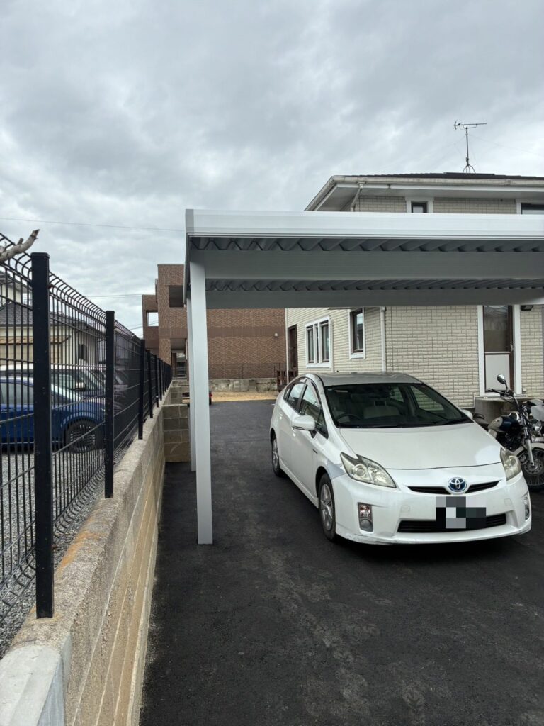 境界ブロック塀沿いまでアスファルト舗装した駐車場と折板カーポート（佐賀県基山町）