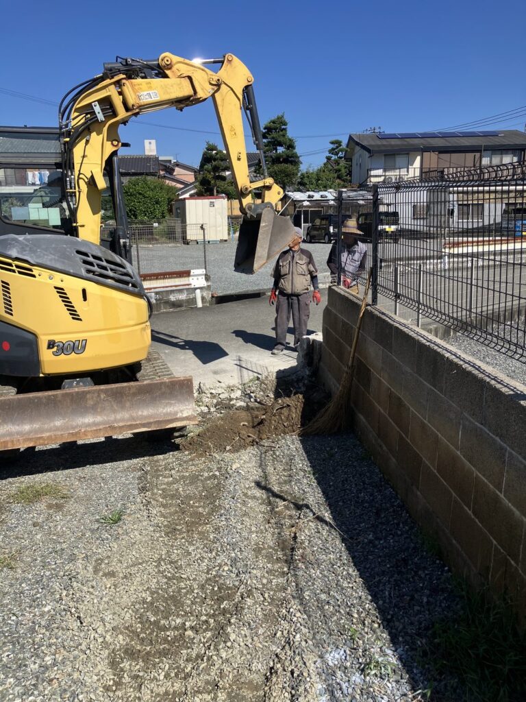 ミニショベルで駐車場の土と砂利を鋤取りする作業（佐賀県基山町）