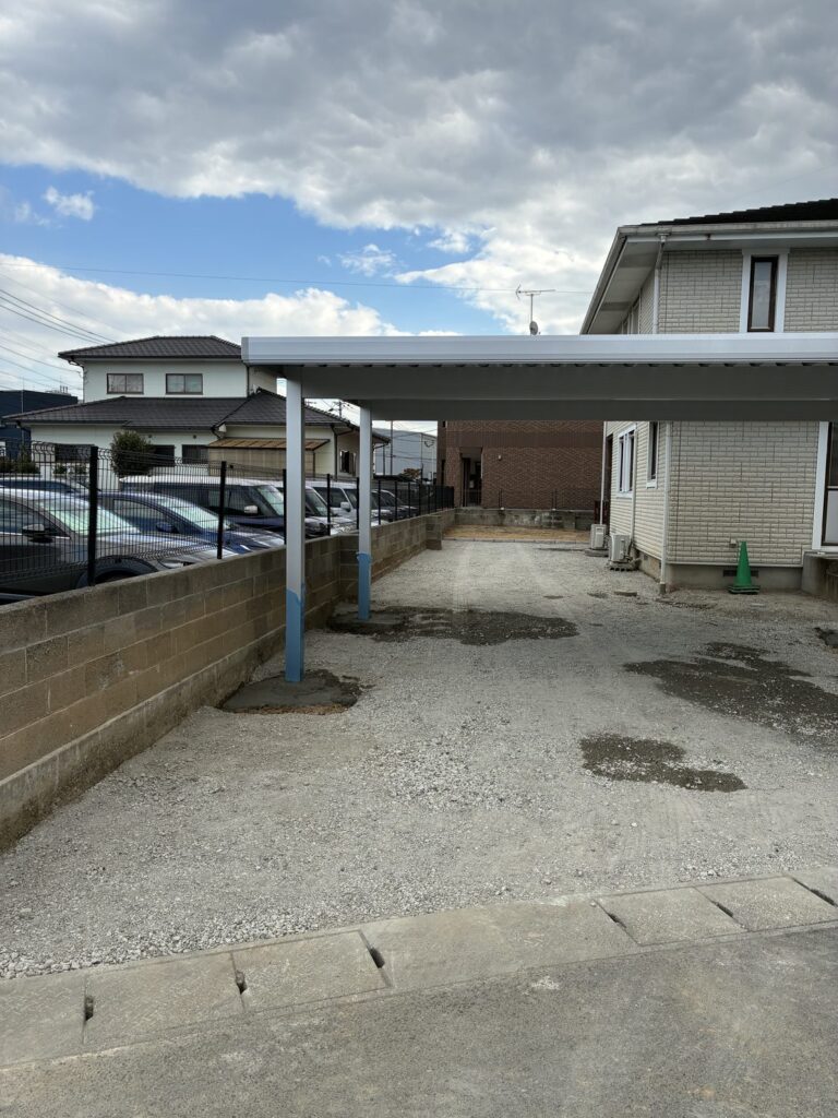 アスファルト舗装の前に建てた折板カーポート アルファNSと締め固めた砕石の下地（佐賀県基山町）