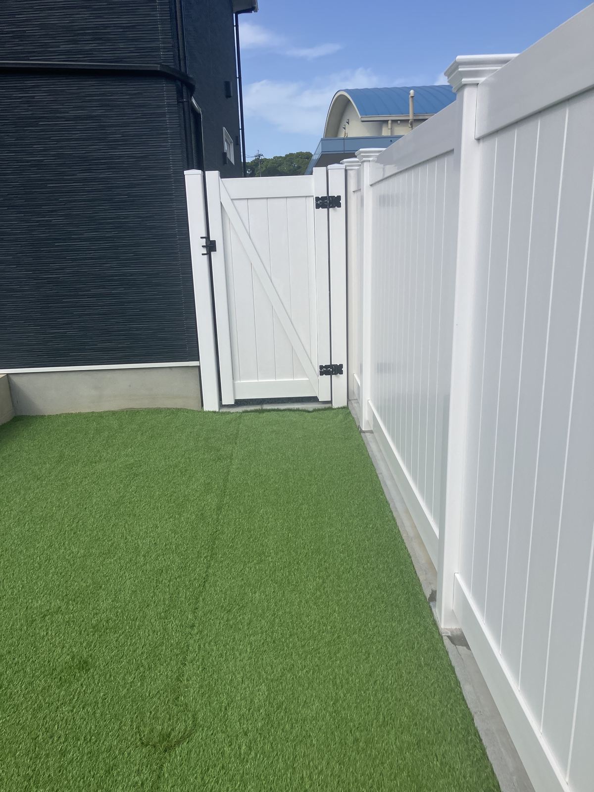 建物脇の通路に設けた片開き門扉と人工芝（福岡県桂川町のフェンス施工実績）