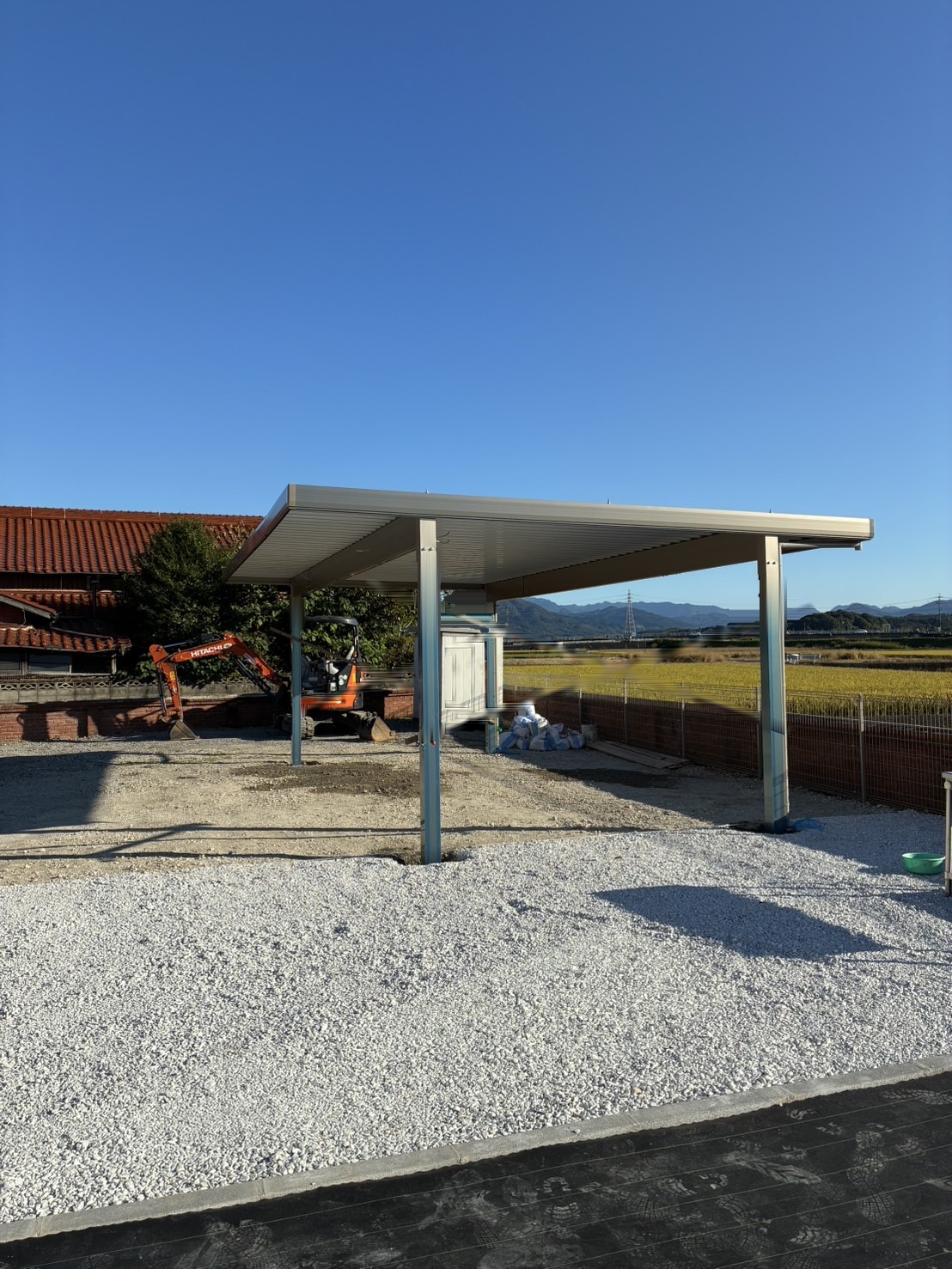 母屋側から見た3台用折板屋根カーポートの全景（福岡県田川市）